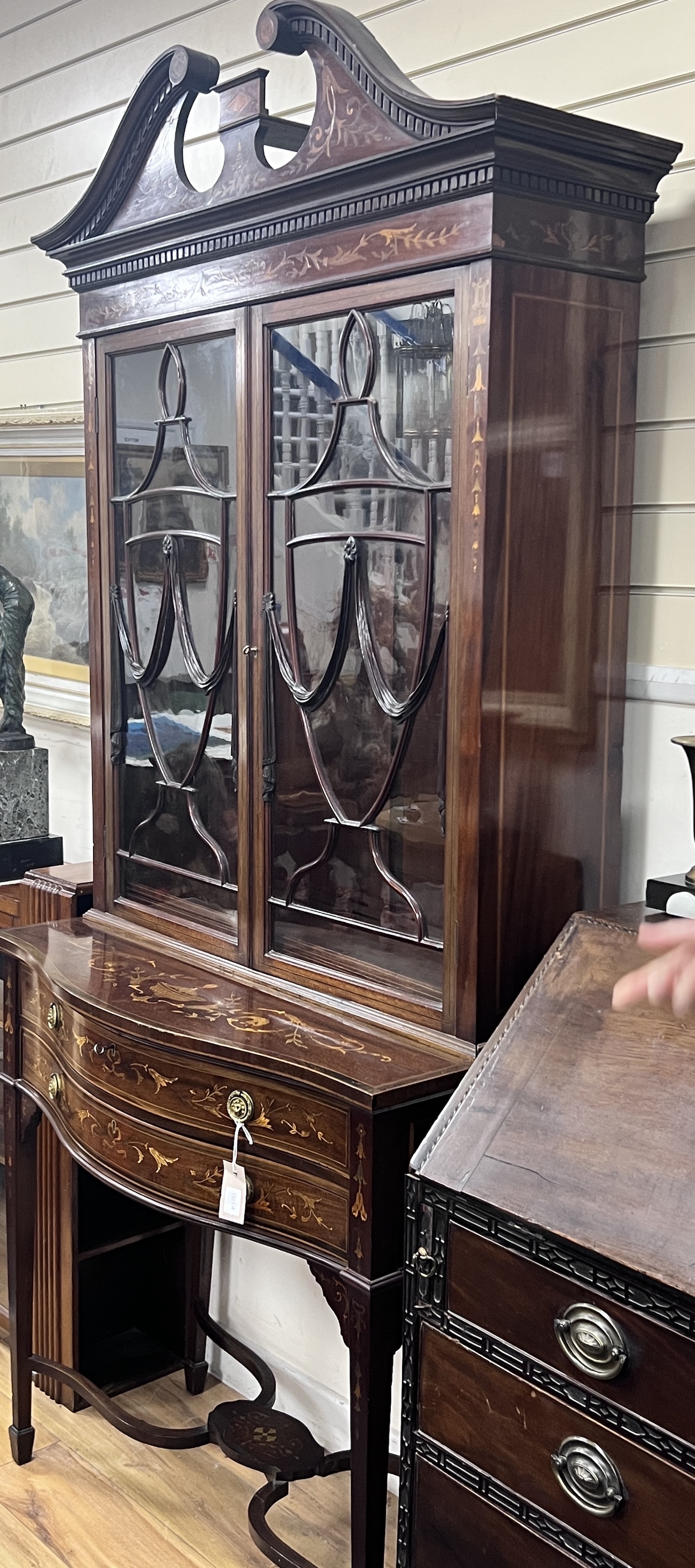 An Edwardian marquetry inlaid mahogany serpentine display cabinet, (bears Edwards & Roberts ivorine plaque), width 92cm, depth 50cm, height 208cm